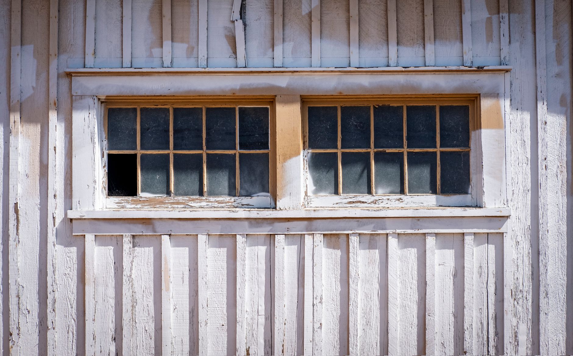 Close-up of a vintage wooden window on a rustic building facade with peeling paint in Riverside, CA